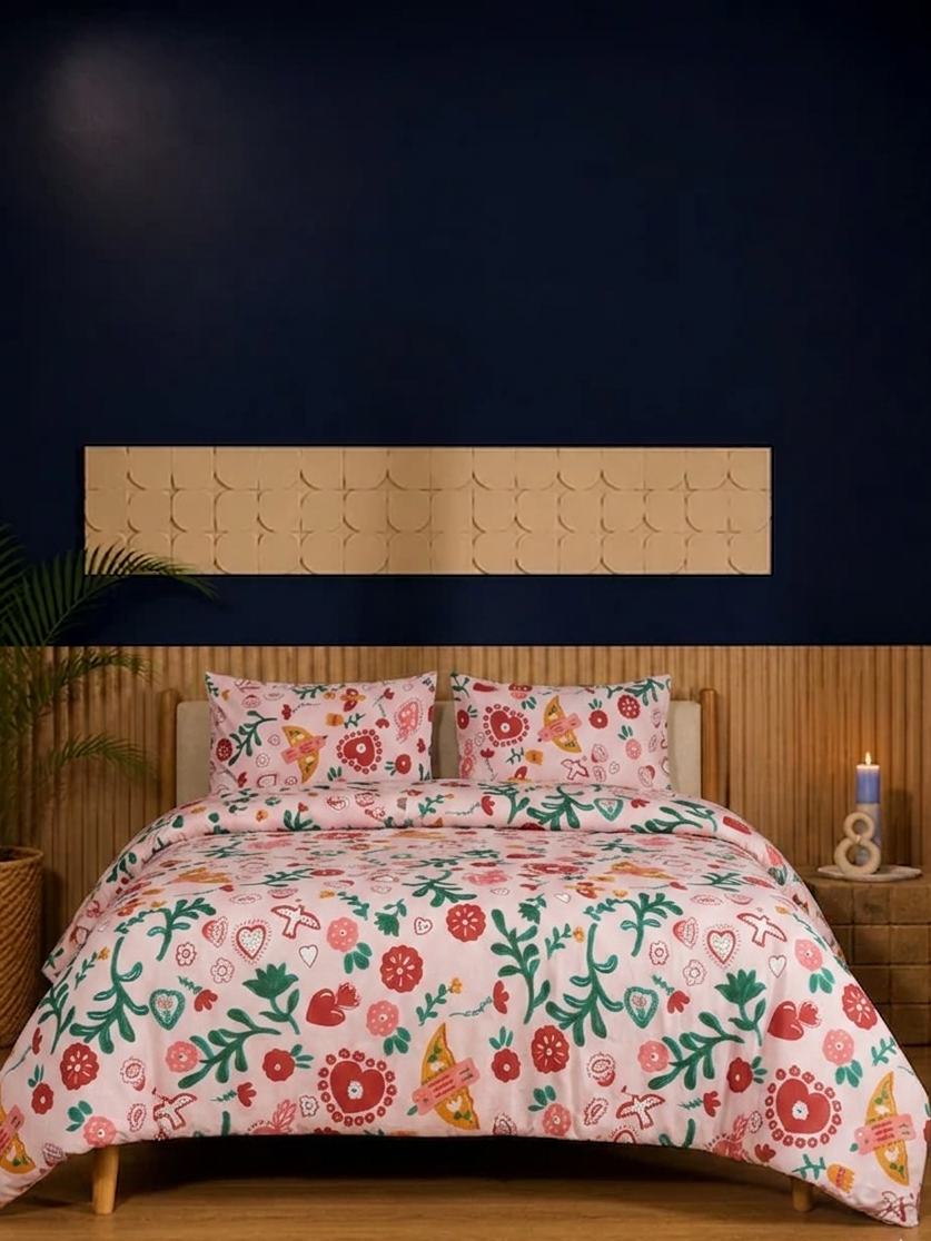 Floral patterned comforter set on a bed with a wooden headboard and nightstands.