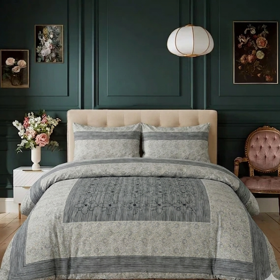 Neatly made bed with gray and beige comforter in a bedroom setting.