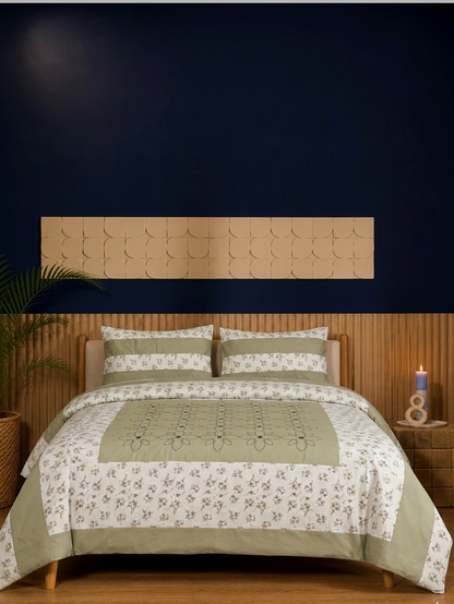 Bed with green and white floral patterned bedding against a dark blue wall.