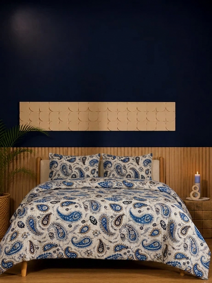 Bed with paisley patterned comforter in a bedroom setting