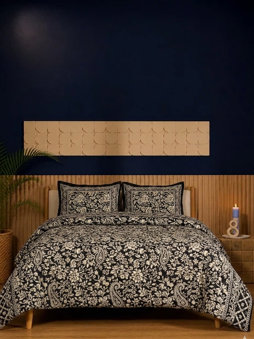 Bed with black and white patterned comforter, pillows, and wooden headboard against a dark wall.