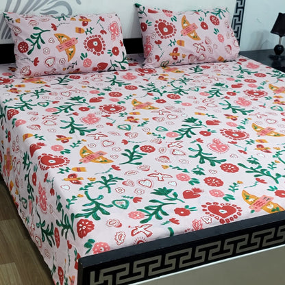 Floral patterned bedsheet with matching pillows on a bed.