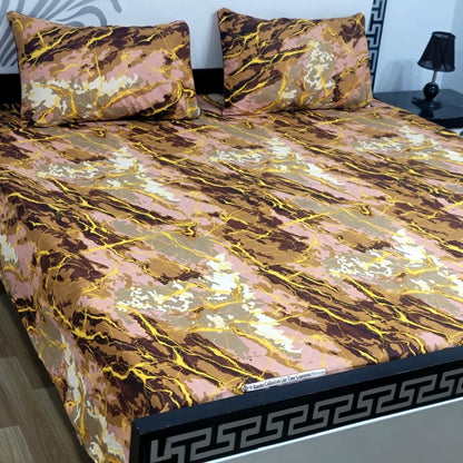 Bed with marbled patterned bedspread and pillows in a room setting.